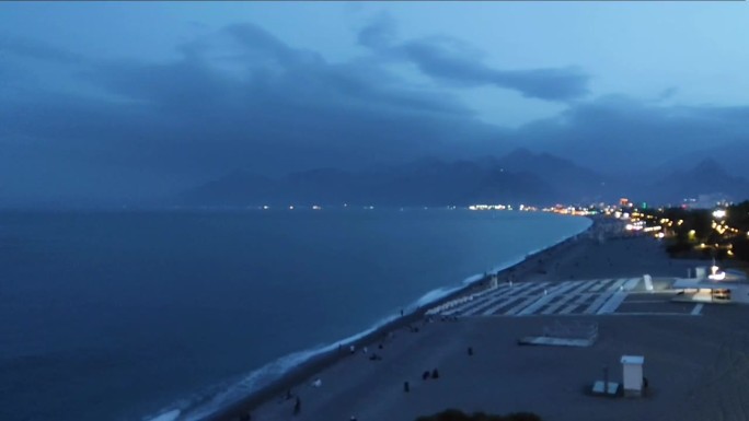 地中海的黑夜和城市的海滩映衬着蓝天