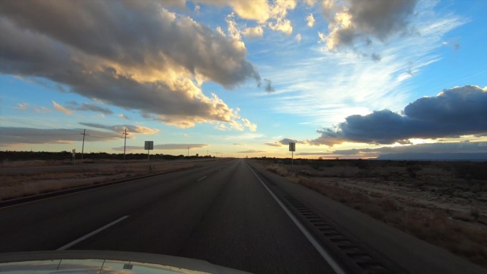 汽车驶入沙漠日落:新墨西哥州