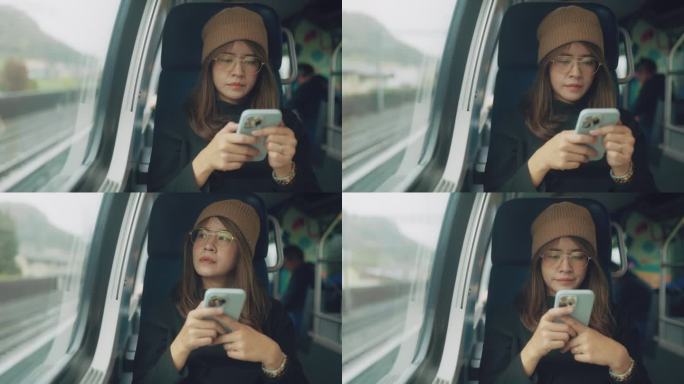 亚洲年轻女性在乘坐火车和公共交通工具上下班时，一边用手机一边透过窗户向外看。