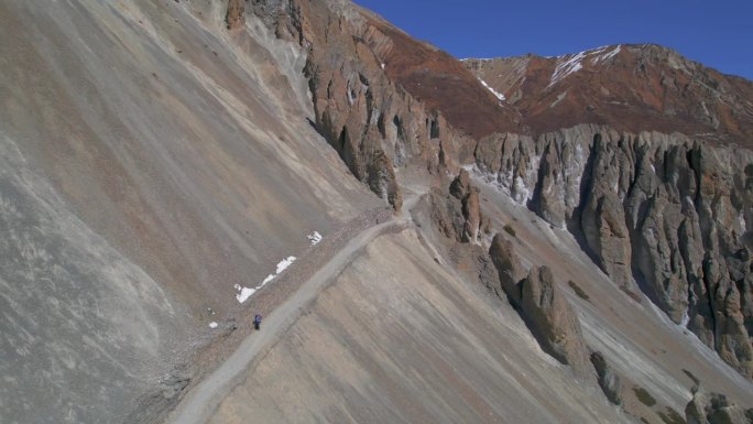 空中拍摄的徒步旅行者独自徒步旅行，在高喜马拉雅山脉的蒂利科大本营。夏季条件下的安纳普尔纳赛道路线