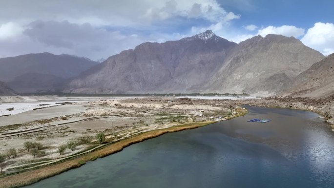 风景鸟瞰图无人机视图飞越小湖和沙丘Sarfaranga寒冷的沙漠，周围的雪帽山在斯卡都，巴基斯坦北部