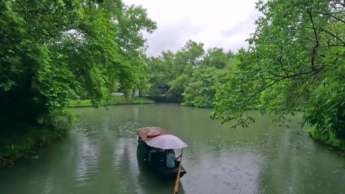 湖面摇橹船游船雨中划船