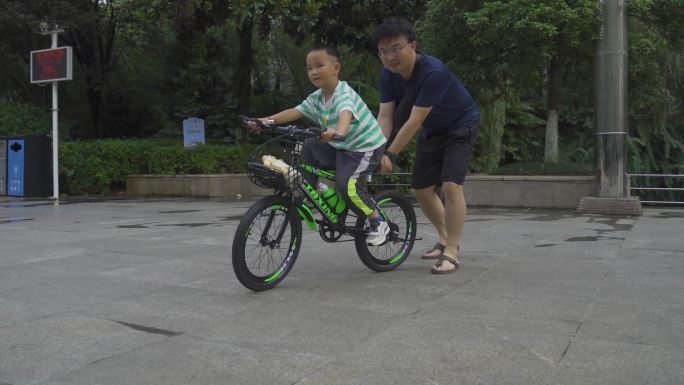 公园爸爸教孩子学骑车特写父亲节 儿同节