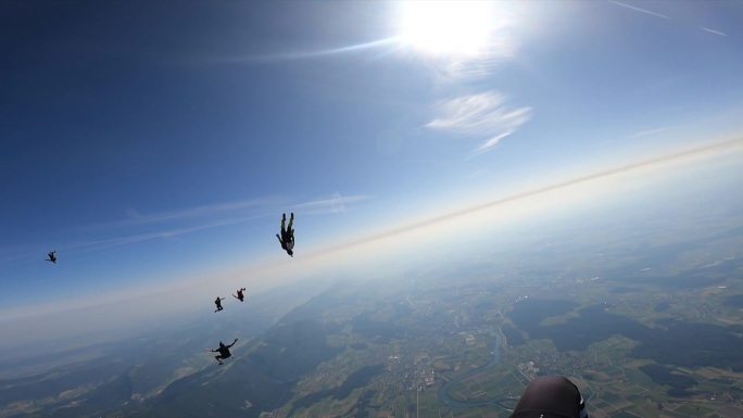 一群跳伞运动员在阳光明媚的日子里跳伞