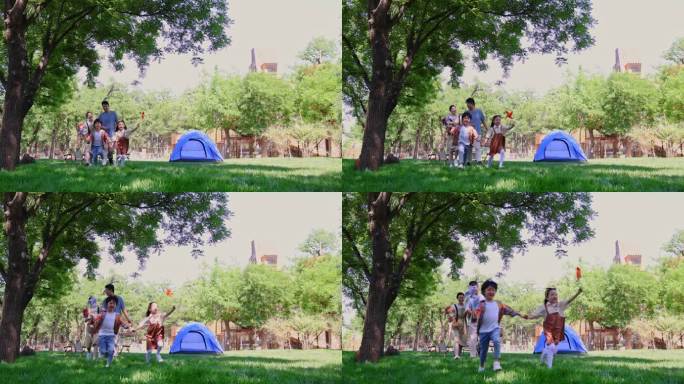 一家四口露营在草地上开心奔跑