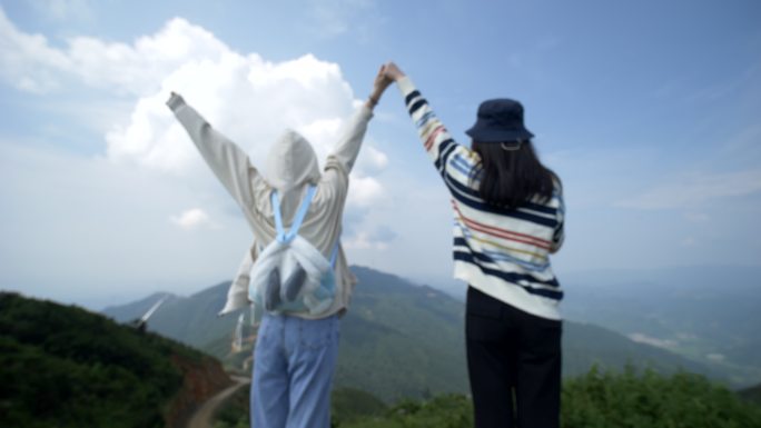 女子山顶牵手呐喊欢呼