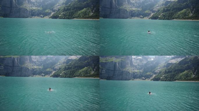 男子在高山湖上游泳，俯瞰高山