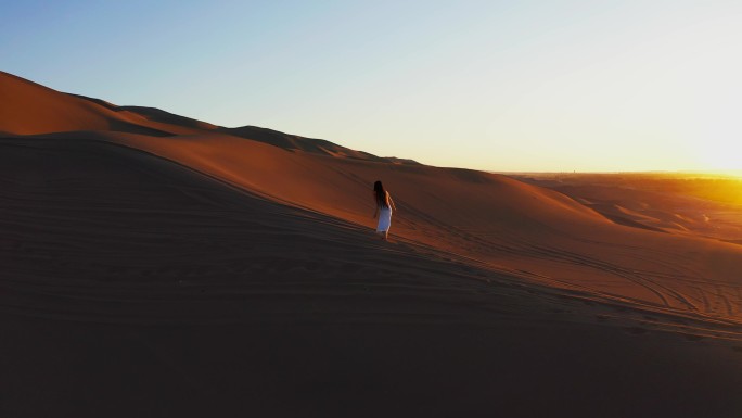 航拍美女走沙漠库木塔格沙漠黄昏沙漠