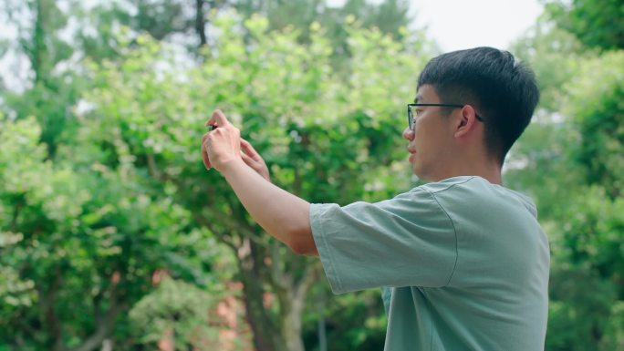 一个男大学生在户外拍照