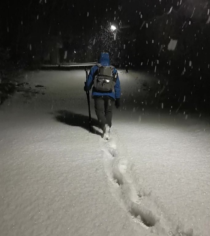 冬天下雪的夜晚在雪中行走的人