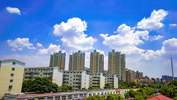 城市延时摄影蓝天白云下的居民楼城市风景。