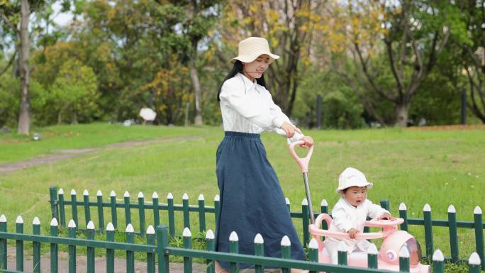 妈妈推着婴儿车逛公园