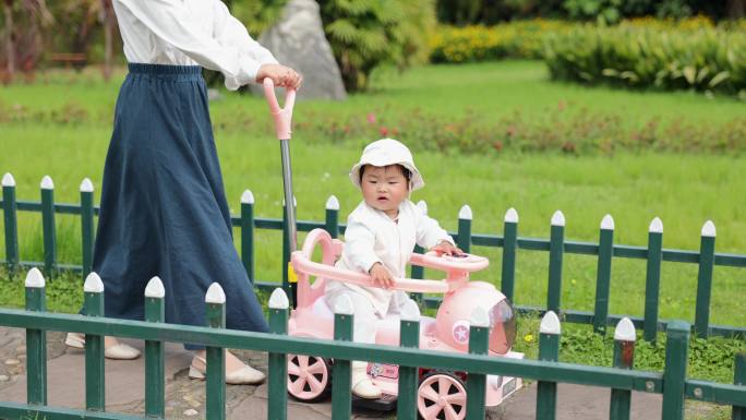 妈妈推着婴儿车逛公园