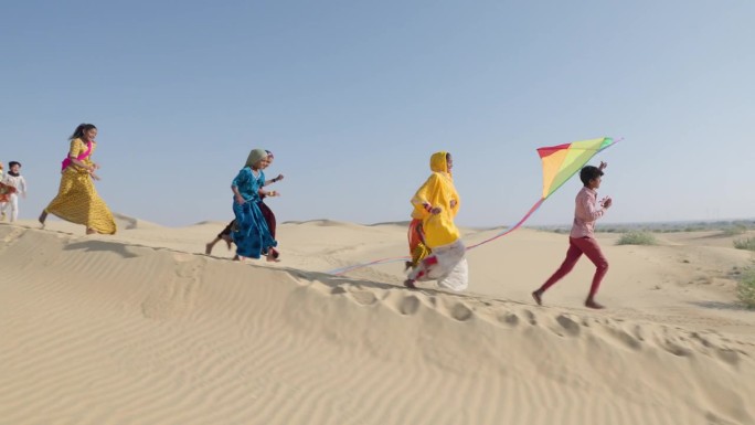 一群快乐的印度孩子带着五颜六色的风筝奔跑，印度