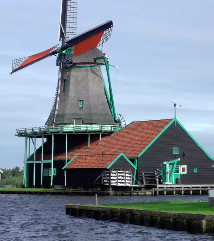 荷兰运河岸边的老式风车。垂直视频