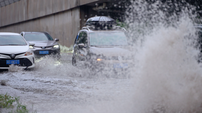 暴雨后城市道路积水中行驶的车辆