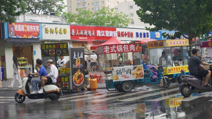 街边占道摆摊小吃街夜市摊雨中冒雨辛苦赚钱