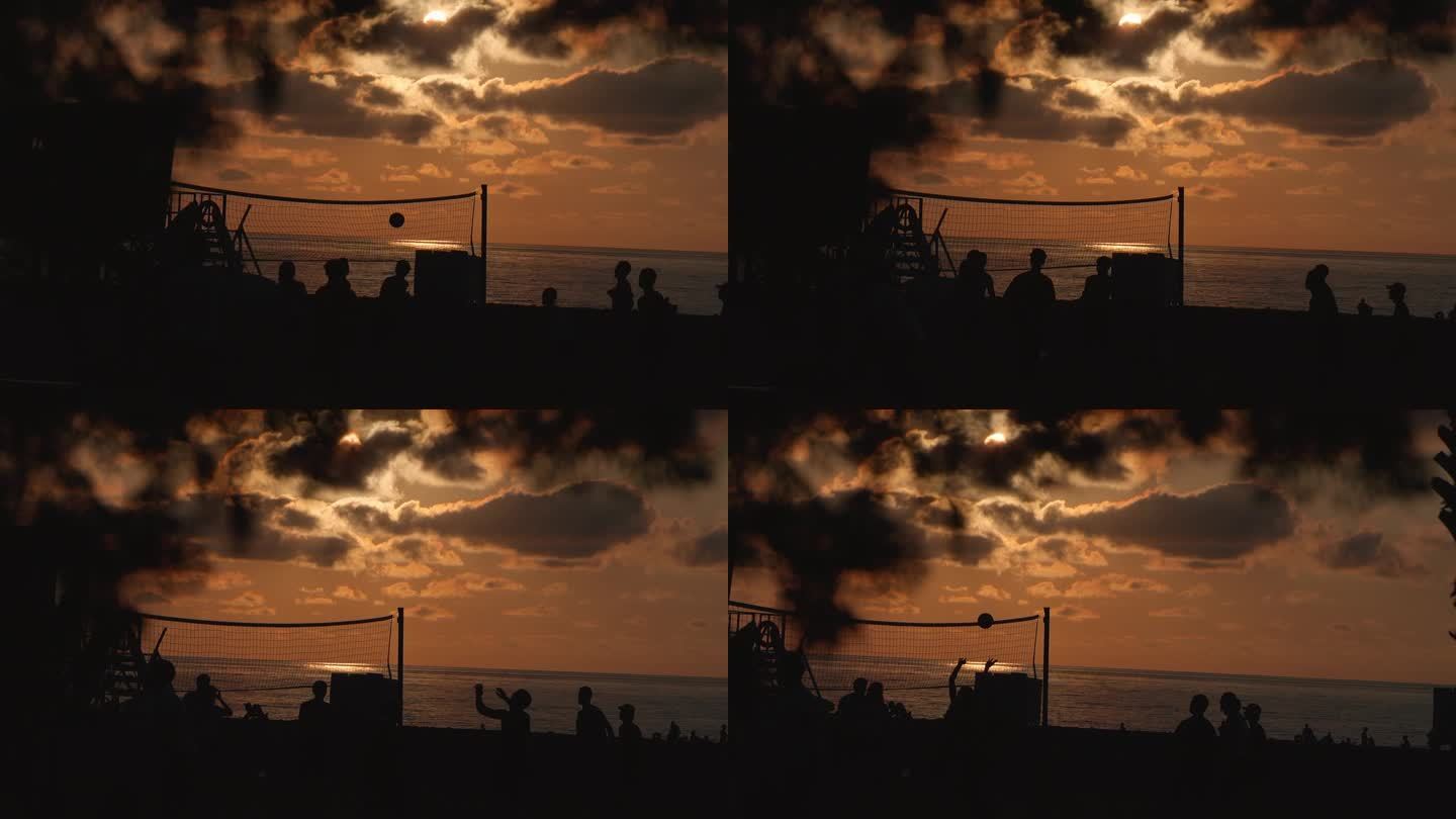 日落时沙滩排球的剪影。