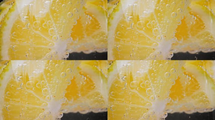玻璃杯里的气泡饮料和柠檬片(特写)。在工作室里用微距镜头在家里制作伏特加或白朗姆酒的酸酒鸡尾酒。饮用
