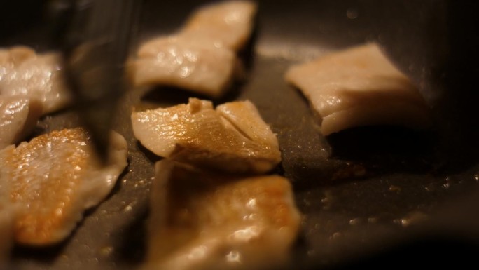 厨师翻转食物鱼。近距离油煎鱼片鳕。烤健康食品。油炸鳕鱼片鱼片与香料特写。健康饮食食品欧米茄3。低热量
