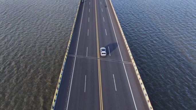 航拍汽车在靠海桥上行驶