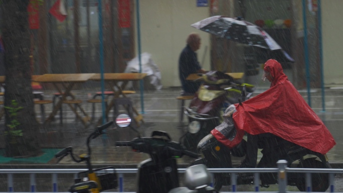 城市街道暴雨下雨打伞淋雨冒雨骑电动车穿行