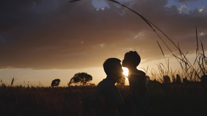 夕阳下孩子亲吻爸爸的额头