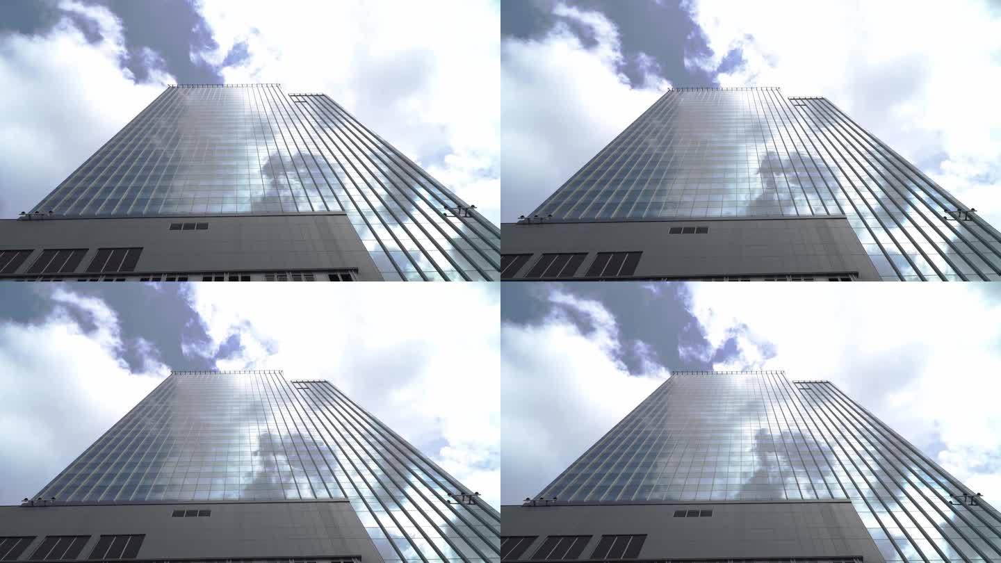 在蓝色晴朗的天空背景下，高层玻璃建筑和深色钢窗系统的景色。未来建筑的经营理念，仰望着楼顶的阳光