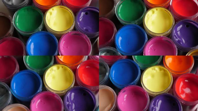设置水粉颜料在罐子明亮的颜色接近。旋转套多色水粉上的塑料罐。旋转多色背景。多色涂料的背景。创意绘画艺