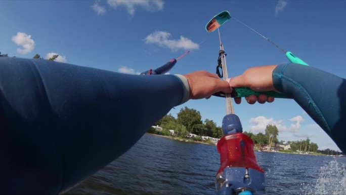 POV可穿戴相机在阳光明媚的日子里观看蓝色海浪上的风筝冲浪