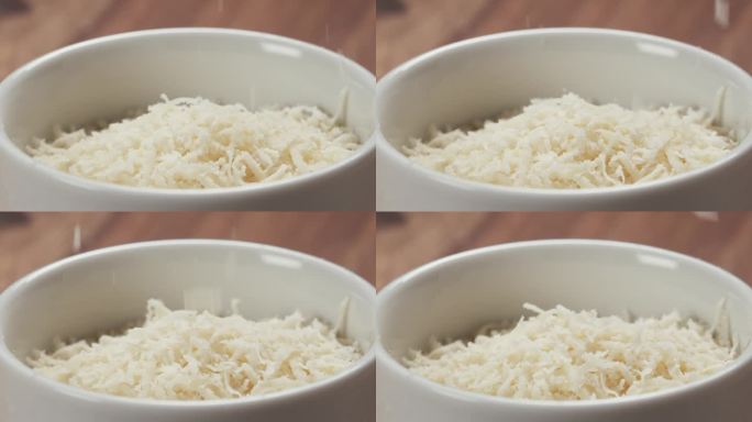 木桌上白色碗里陈年帕尔马干酪的慢镜头特写