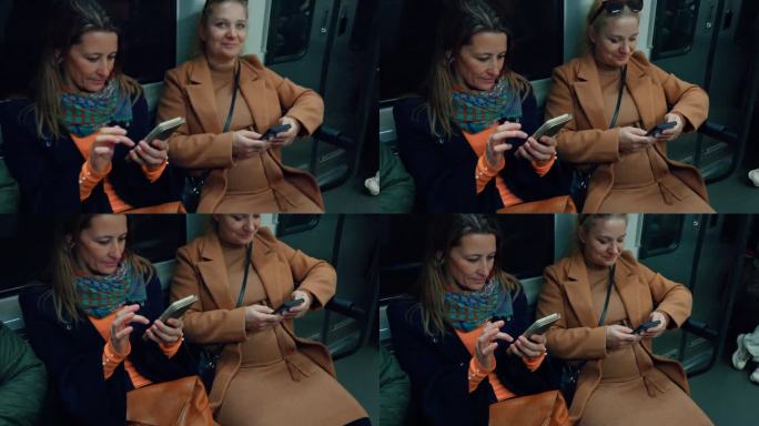 两名女子在乘坐地铁时使用智能手机