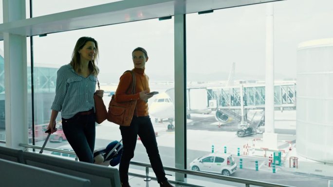 WS两名女性在机场登机口检查智能手机