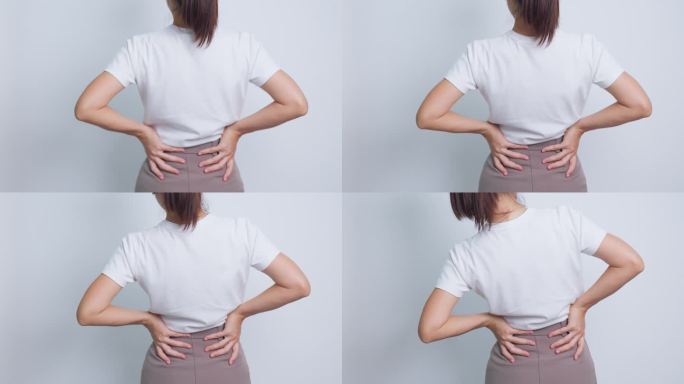 灰色背景为肌肉疼痛的成年女性。因梨状肌综合征、腰痛和脊柱受压而腰痛的老年妇女。办公室综合症与医学概念