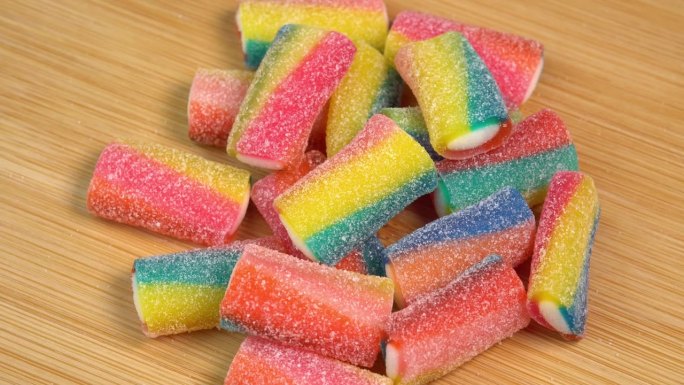 多色软糖果冻在木板上旋转。用糖和明胶制成的彩色软糖果冻糖果