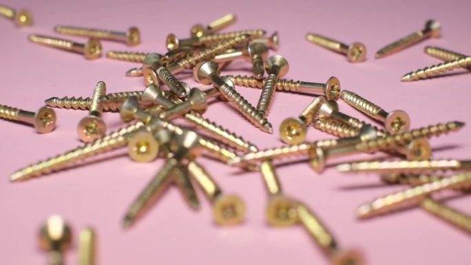 微距拍摄的金属螺栓在一个粉红色的背景。