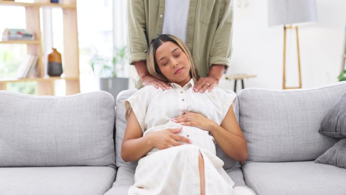 怀孕，放松和男人按摩女人支持，照顾和安抚母亲在客厅，房子或公寓。夫妻、孕妇及伴侣帮助背部疼痛或用手触