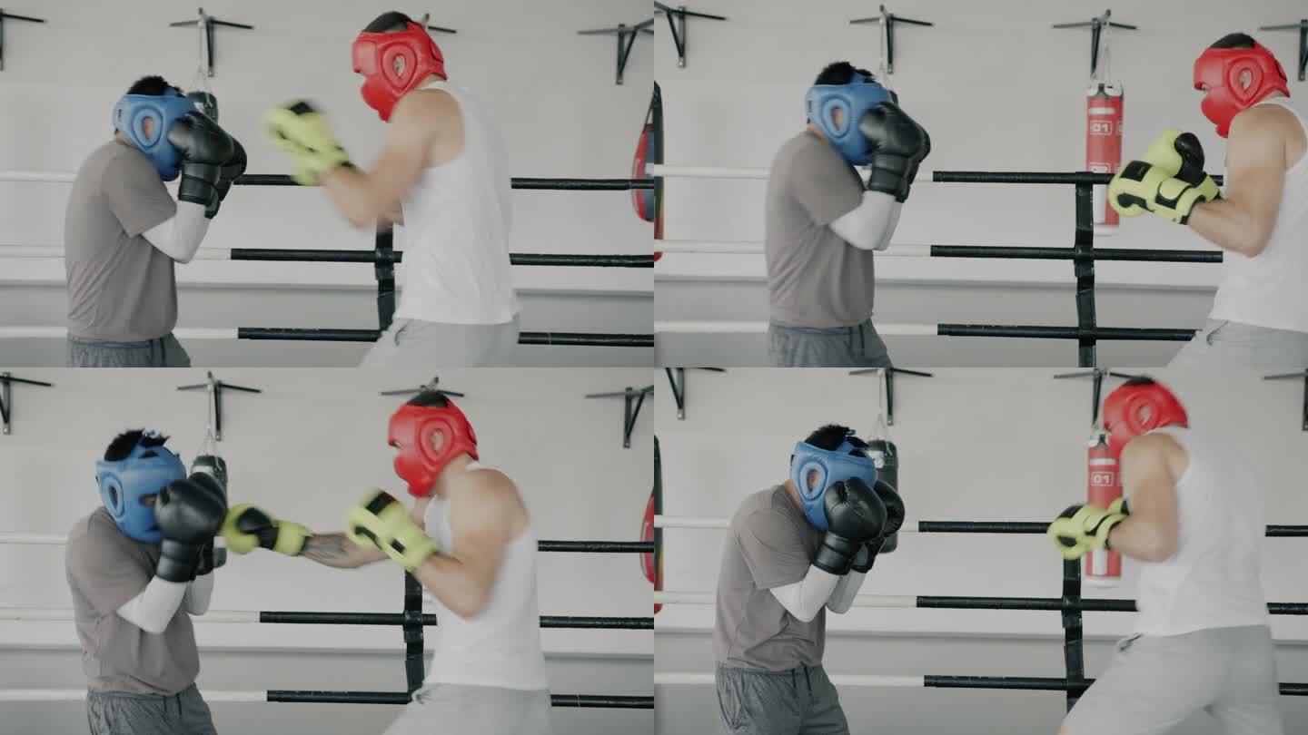 两个年轻的拳击运动员戴着头盔和手套在体育馆里进行拳击训练
