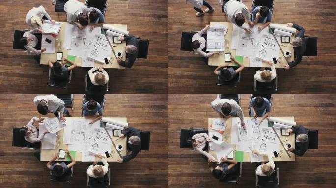 商务人士围坐在会议室桌旁讨论新的可持续共享办公空间的建筑方案