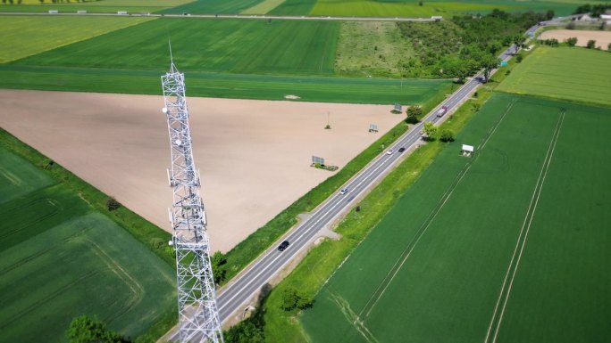 鸟瞰图:位于乡村公路附近的蜂窝天线与过往的车辆。传送数字信号的电信塔。无线通信，数据传输，5G。
