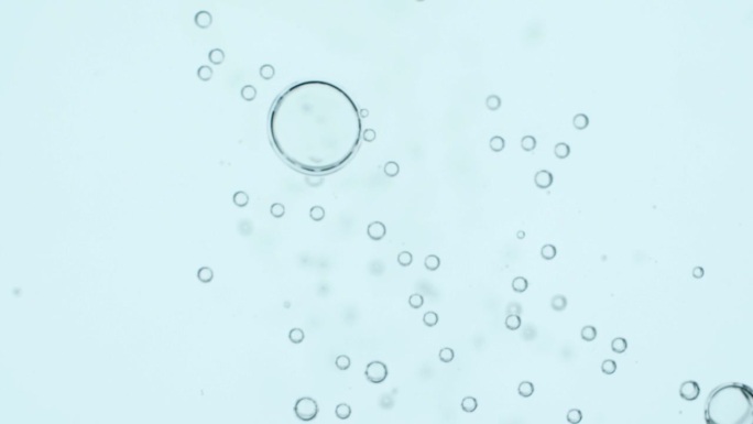 俯视图特写场景上的小气泡接合在一起，成为一个更大的，打破孤立的白色背景，气泡质地的苏打水饮料时，气体