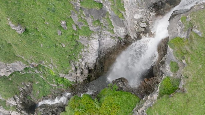 空中无人机看到的河流和瀑布流经绿色的高山牧场