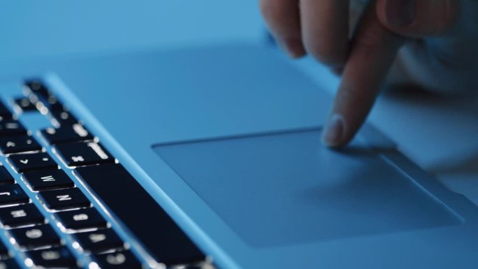 女性手使用笔记本电脑触摸板