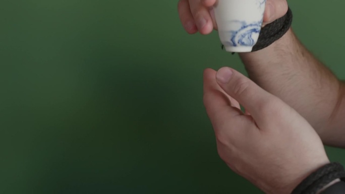 在传统的茶道上，茶师将茶碗递给男人，双手特写。
