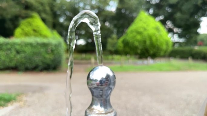一个慢镜头的水从一个公园的饮水机流出