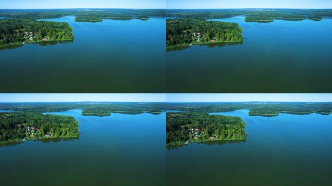 壮丽的鸟瞰平静的湖泊与岛屿在波兰。天堂湖岸边的乡村房屋。水面上的宁静。壮观美丽的湖鸟瞰图。史诗般的惊