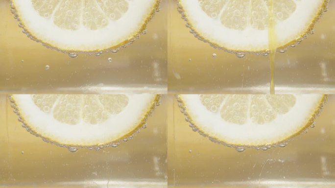 柠檬片，泡在柠檬水里。蜂蜜顺着它流下来。特写慢镜头。