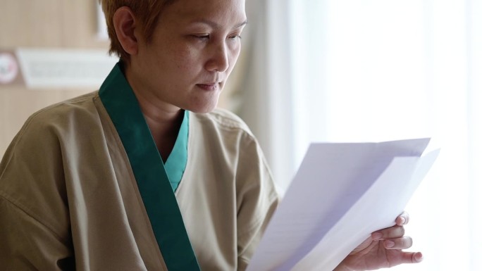 亚洲女病人忧心忡忡地阅读医院费用。金融危机