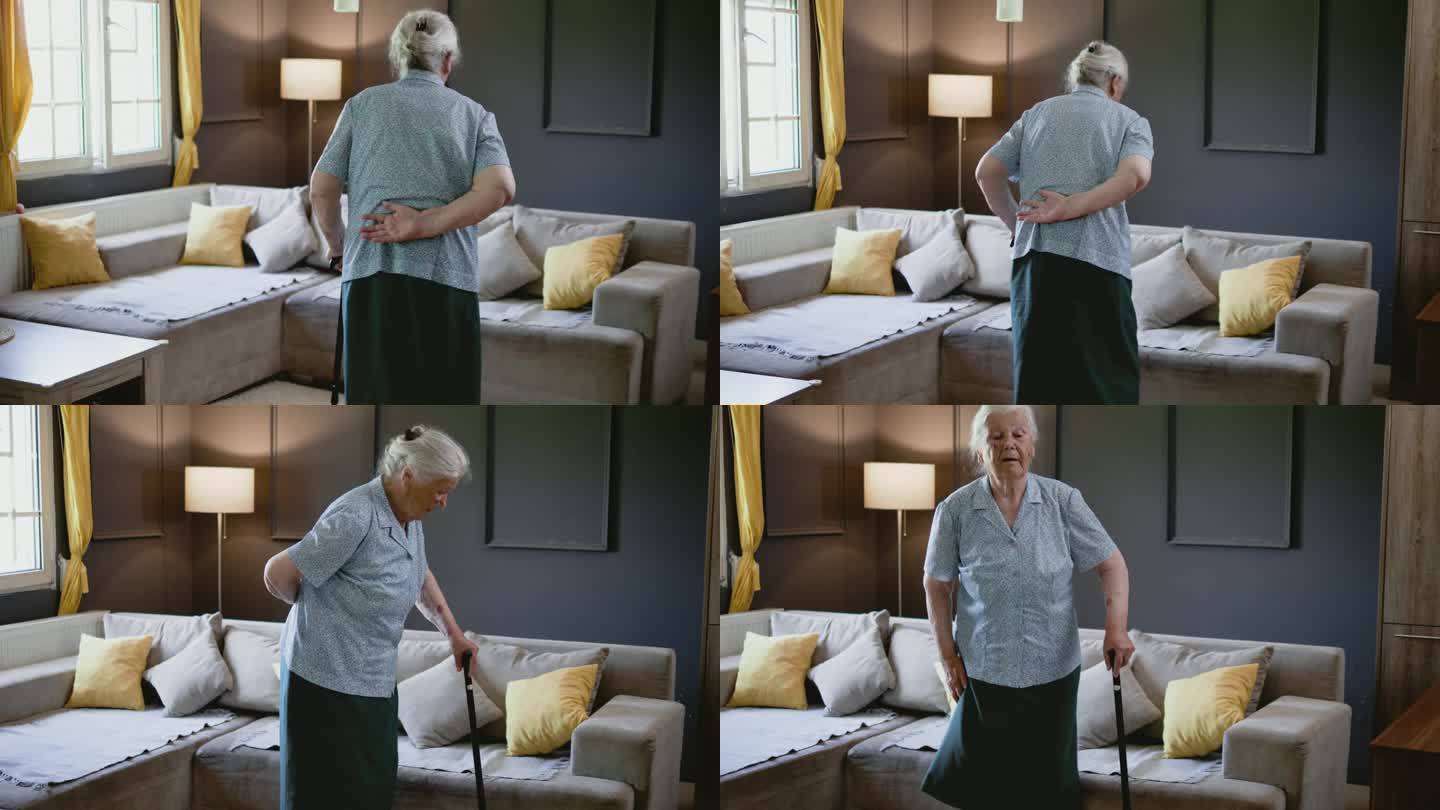 80年代退休的老妇人拄着拐杖试图坐在客厅的沙发上。这位老人走路很吃力。膝关节和关节疼痛