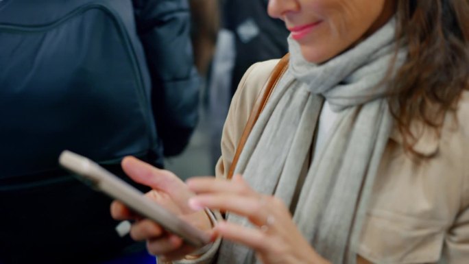MS Woman在乘坐地铁时使用她的智能手机